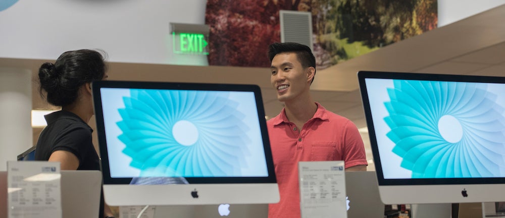 People talking around MacBooks.